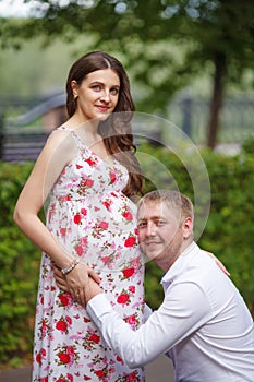 Pregnant woman with husband walking in the park