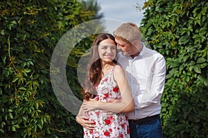 Pregnant woman with husband walking in the park
