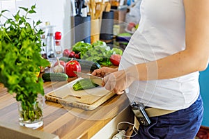 Pregnant woman with insuline pump preparing healthy food