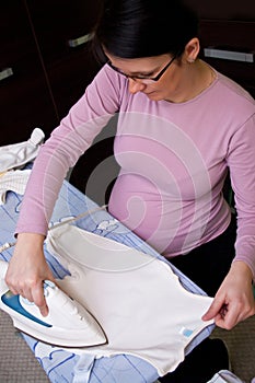 Pregnant woman ironing