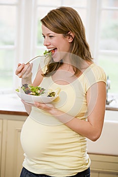 Una mujer en La cocina comer ensalada 