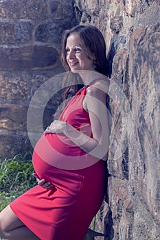 Pregnant woman leaning on wall