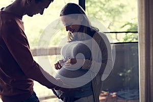 Pregnant woman letting her husband feel the baby