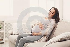 Pregnant woman listening music in headphones