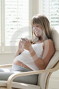 Pregnant Woman Listening Music From MP3 Player