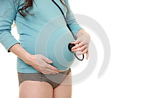 Pregnant woman listening stethoscope of her baby