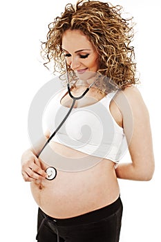 Pregnant woman listens to palpitation of the child photo