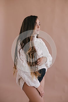 Pregnant woman with long hair in white sweater.