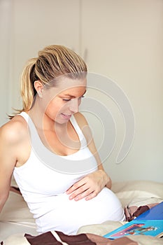 Pregnant woman looking at baby books