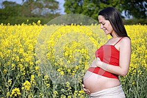 Pregnant woman looking down at bump