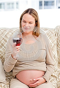 Pregnant woman looking at a glass of red wine