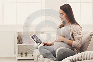 Pregnant woman looking at her baby sonography