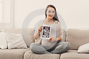 Pregnant woman looking at her baby sonography