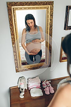 Pregnant woman looking her belly