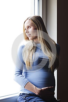 Pregnant woman looking out the window