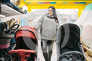 Pregnant woman looking for pushchair in store