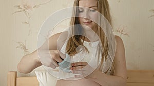 Pregnant woman looking at tiny clothes for future child