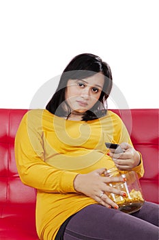 Pregnant woman looks bored while watch television