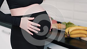 Pregnant woman loves her unborn baby and caressing the tummy