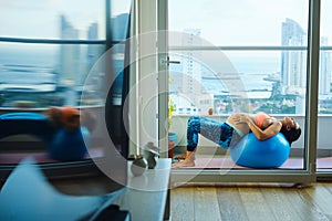 Pregnant Woman Lying Back on Exercise Ball at Home