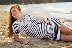 Pregnant woman is lying on beach