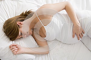 Pregnant woman lying in bed sleeping