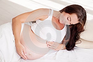 A pregnant woman is lying in bed waiting for the birth of a child