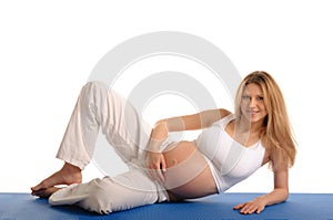 Pregnant woman lying down and practicing yoga