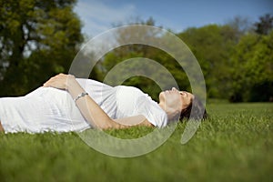 Pregnant Woman Lying On Grass