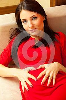 Pregnant woman makes heart shape over belly