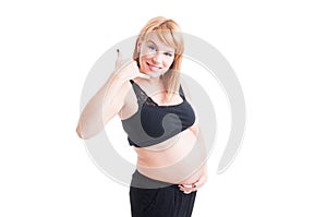 Pregnant woman making call me gesture with friendly face