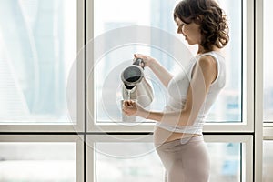 Pregnant woman making cup of hot drink