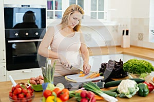 Pregnant woman making a meal in kitchen