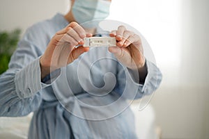 Pregnant woman making test. Close up of fingers holding express antigen covid test, negative result