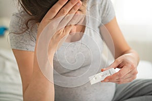 Pregnant woman making test. Close up of fingers holding express antigen covid test, negative result