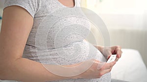 Pregnant woman making test. Close up of fingers holding express antigen covid test, negative result