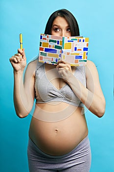 Pregnant woman making to do list packing things for maternity hospital, isolated