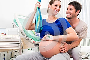 Pregnant woman and man in delivery room of hospital