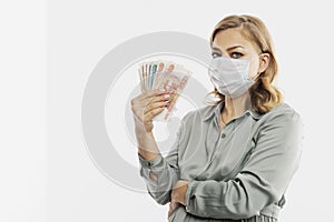 A pregnant woman in a mask holds Russian banknotes in her hand. Maternity capital, government assistance. Space for text. White
