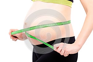 Pregnant woman measures the abdominal circumference centimeter tape, closeup photo