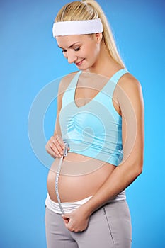 Pregnant woman measures her belly