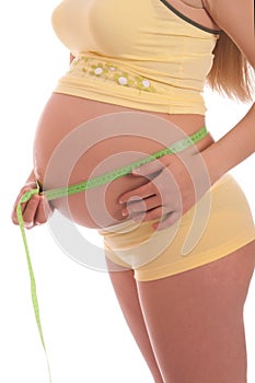 Pregnant woman measures her belly