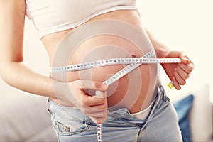 Pregnant woman measures her belly