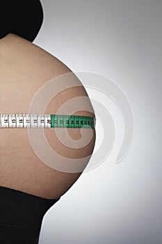 Pregnant Woman Measuring Abdomen With Tape Measure