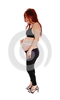 Pregnant woman measuring belly.