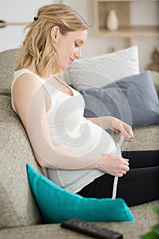 Pregnant woman measuring belly