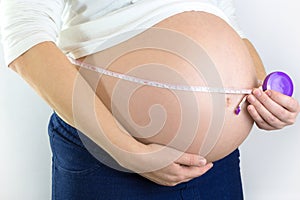 Pregnant woman measuring her belly