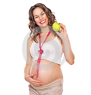 Pregnant woman measuring her big belly and eating apple