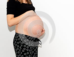 Pregnant woman model touching her pregnancy belly abdomen, isolated on white background