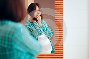 Pregnant Woman with Morning Sickness Looking in the Mirror photo